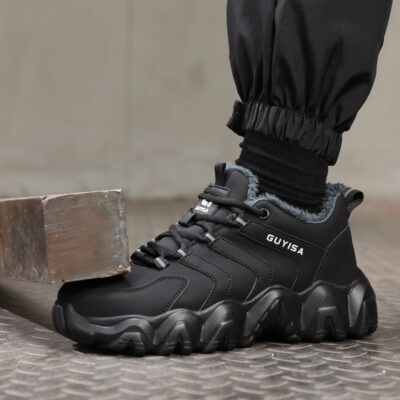 Black steel toe work shoe beside a metal block